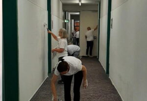 Mehrere Ehrenamtliche der AWO Wiesbaden streichen Wände und Türen im Rahmen eines sozialen Projekts