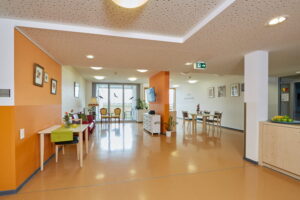 Einladende Sitzgruppe in einem farbenfrohen Aufenthaltsbereich des Konrad Arndt Hauses, ideal für kleine Gesprächsrunden