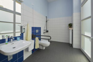 Barrierefreies Badezimmer im Robert Krekel Haus mit Waschbecken, WC, Haltegriffen und bodengleicher Dusche