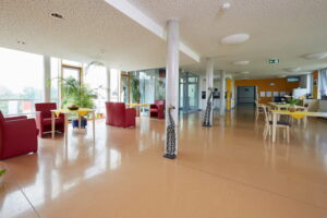 Großzügiger Gemeinschaftsbereich im AWO Pflegezentrum mit Blickachsen nach draußen und moderner, freundlicher Innengestaltung