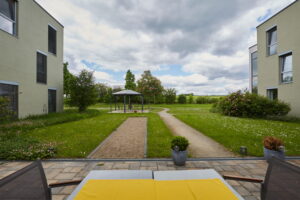 Gepflegte Außenanlage des Konrad Arndt Hauses mit Gartenpavillon, Boule-Bahn und weitem Blick in die Natur