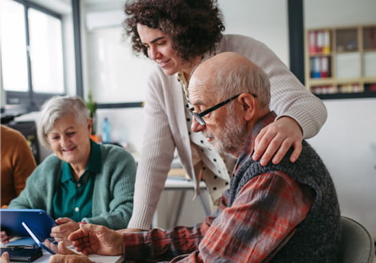 Digitallotsen der AWO Wiesbaden bei der digitalen Unterstützung Eine Beraterin unterstützt ältere Menschen bei der Nutzung eines Tablets im Rahmen des Angebots Digitallotsen der AWO Wiesbaden