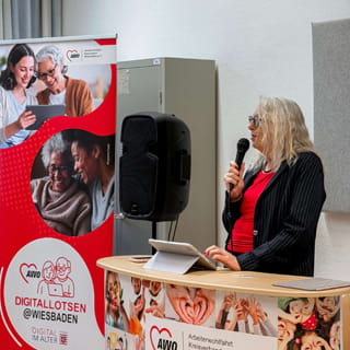 Eine Rednerin spricht am Stehpult bei einer Veranstaltung der Digitallotsen in Wiesbaden